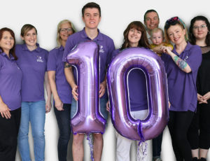 Staff in purple T Shirts celebrating 10 years of Ewan the Dream Sheep