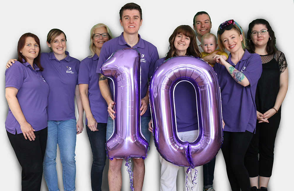 Staff in purple T Shirts celebrating 10 years of Ewan the Dream Sheep