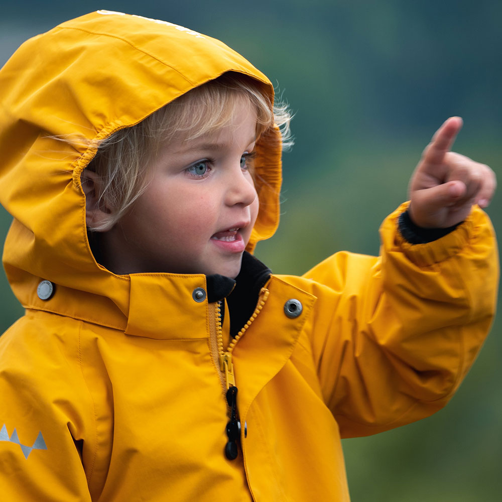 Boy in yellow rain coat for train story
