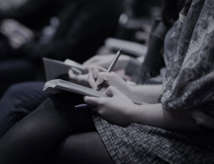 People sat in a row taking notes at a seminar