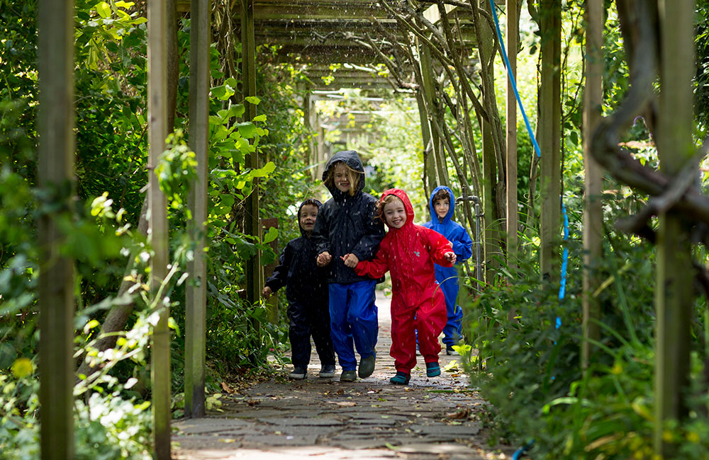 Kids in red and blue Muddy Puddles rainwear