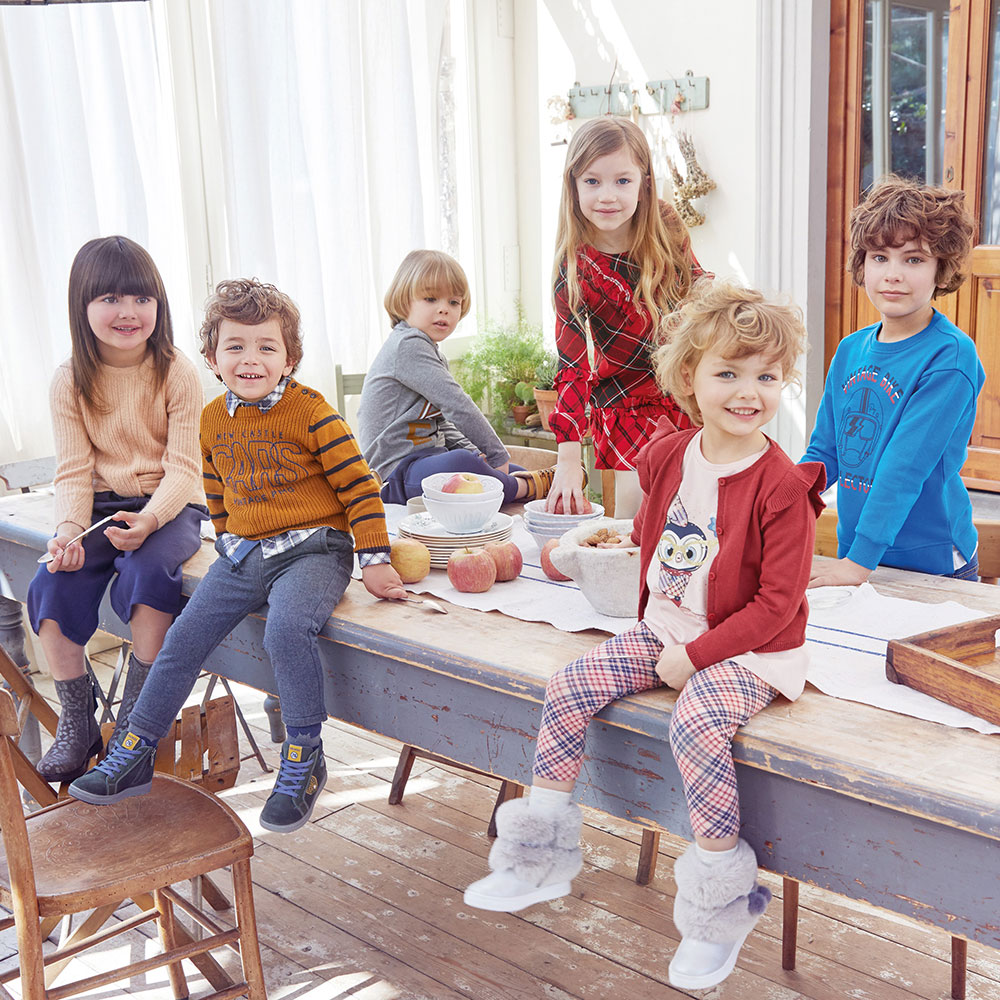 Little children sat on kitchen table