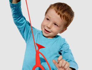 Boy stretching Little Concepts red toy
