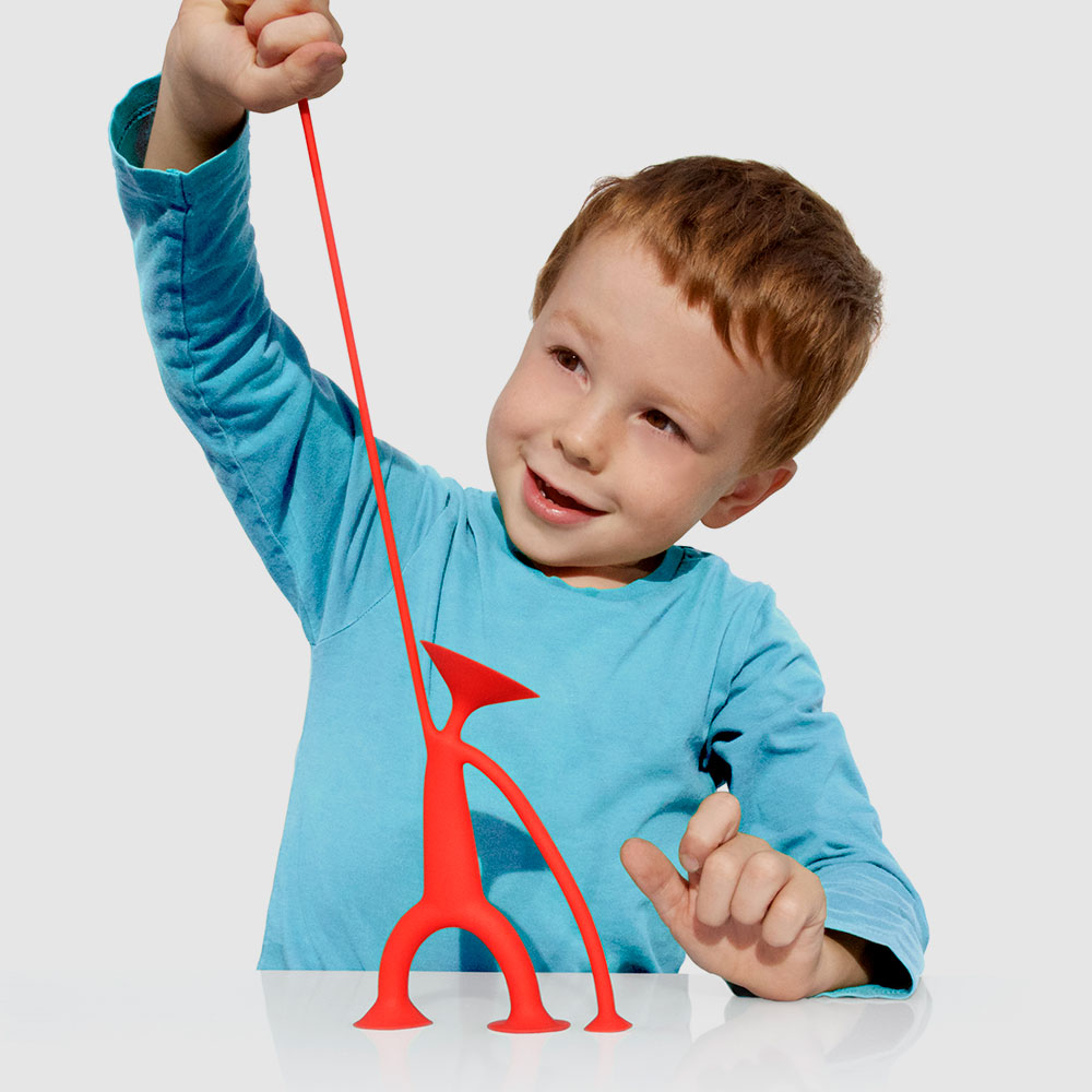 Boy stretching Little Concepts red toy