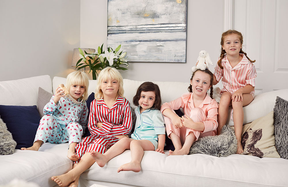 Five children on a white sofa wearing Sleepy Wilson pyjames