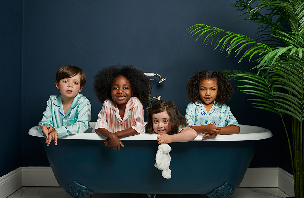 Four children in a bath wearing Sleepy Wilson pyjamas