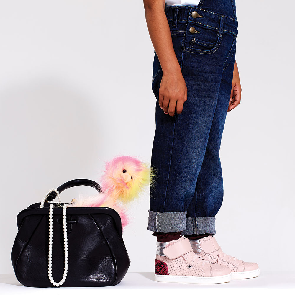 Young Girl standing next to a black bag