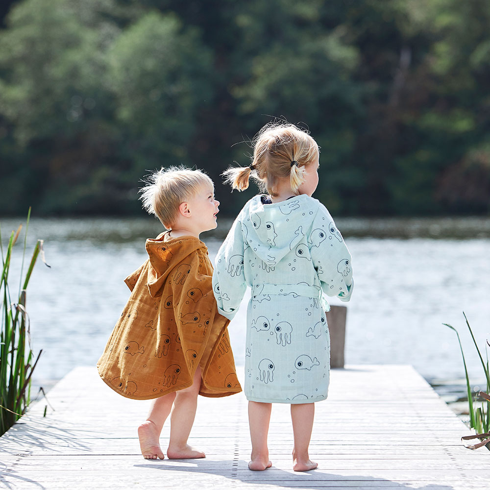 Two children wearing Done by Deer dressing gowns
