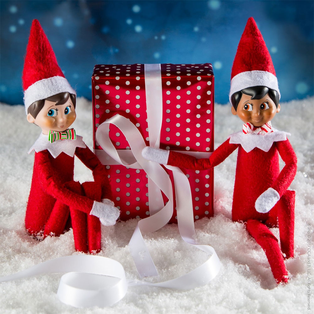 The Elf on the Shelf with red gift wrapped present and silver bow