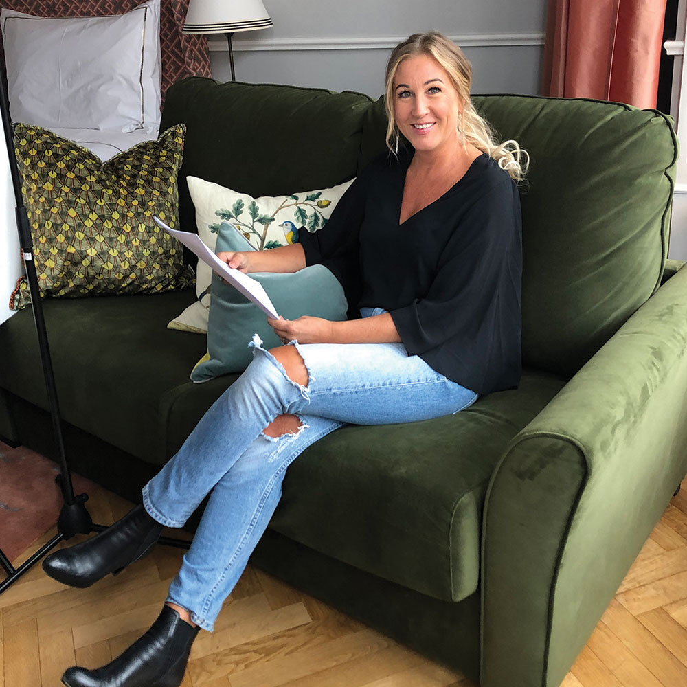 Linda Sätterström of Elodie sat in green chair reading a magazine