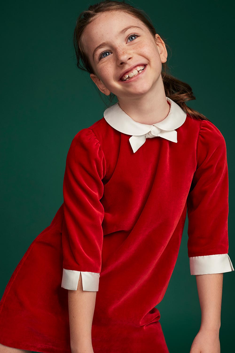 Young girl wearing Il Gufo Christmas red dress