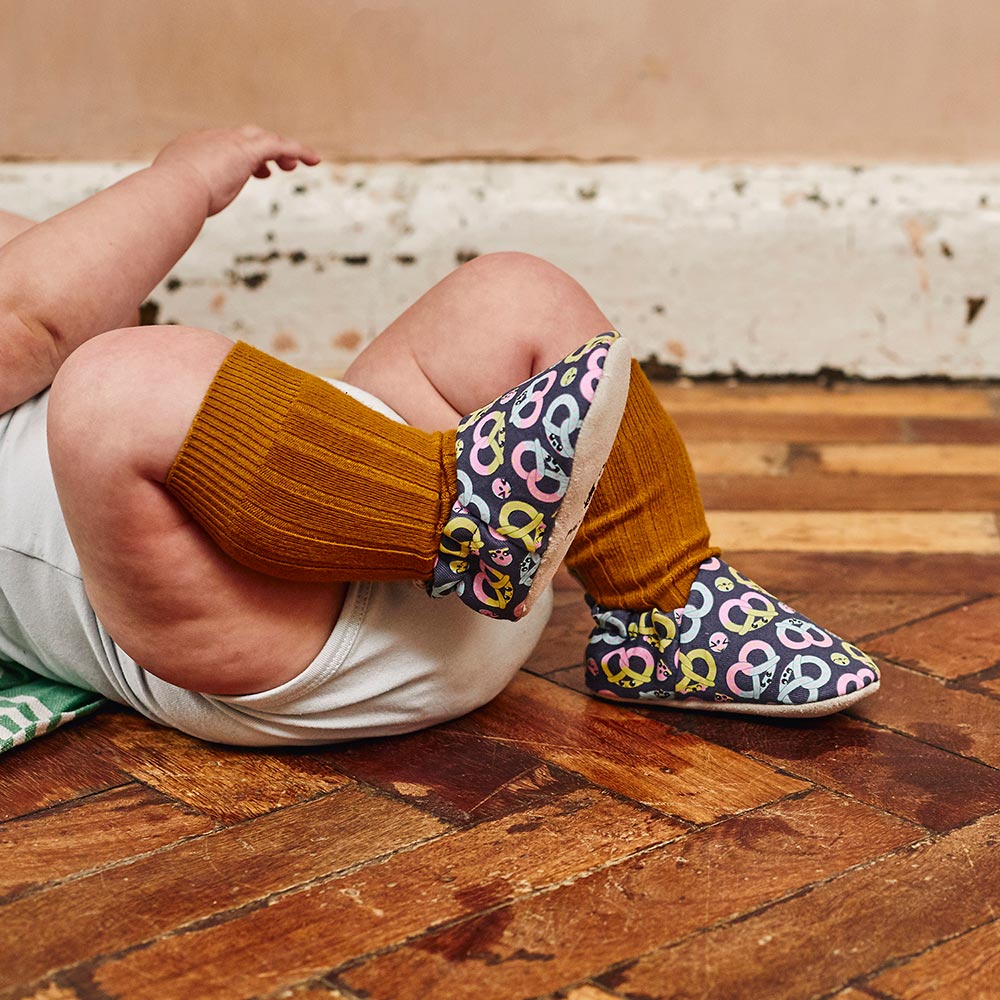 Baby laid down in colourful Poco Nido baby shoes