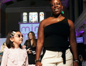 Amanda Rabor on the catwalk with a young girl
