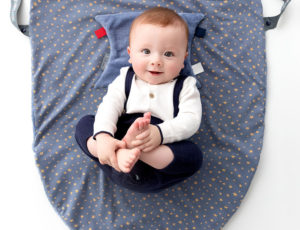 Cheeky Chompers baby with teething aid on a play mat
