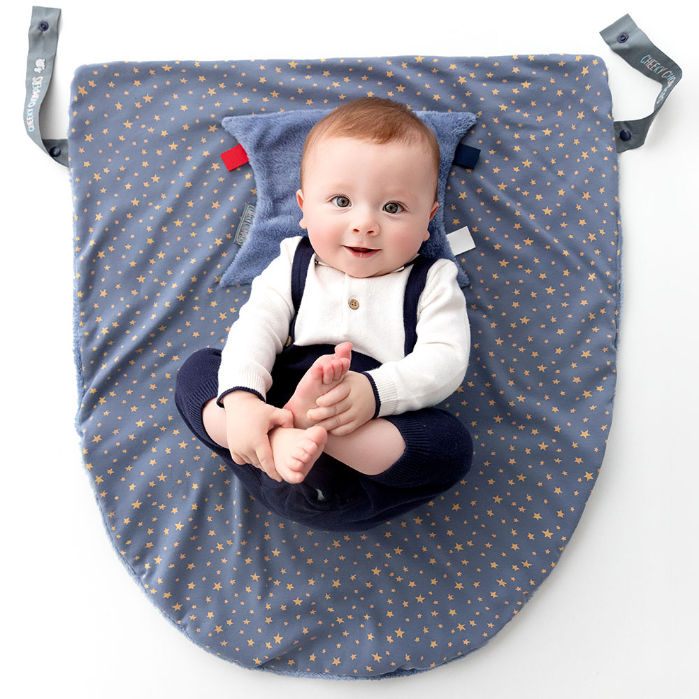 Cheeky Chompers baby with teething aid on a play mat