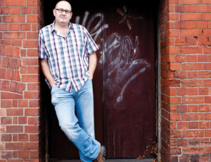 Luke Conod stood in a door way with red brick walls