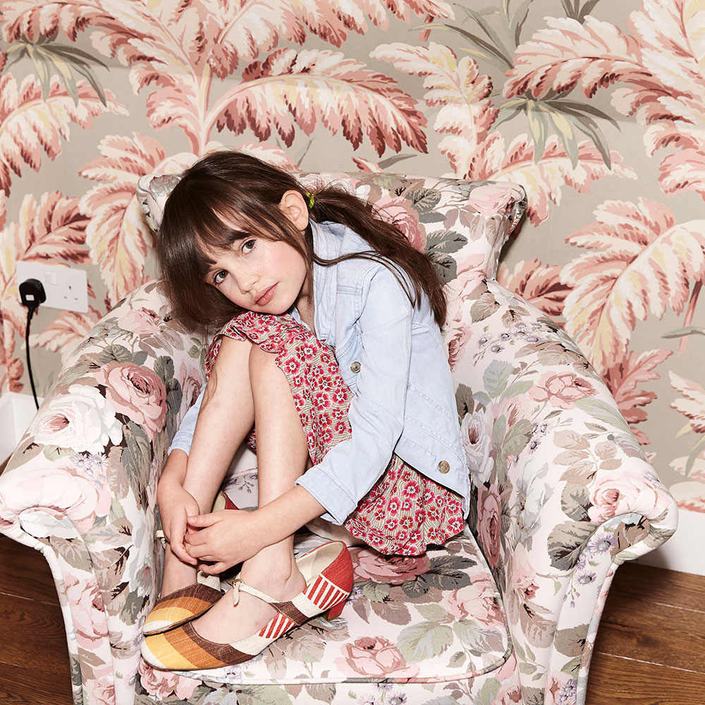 Young girl sat on patterned chair