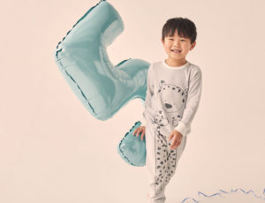 Young Boy in MORI pyjamas with number 5 balloon