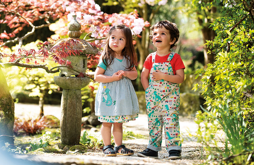 boy and girl in sttod in garden in colourful Frugi clothing