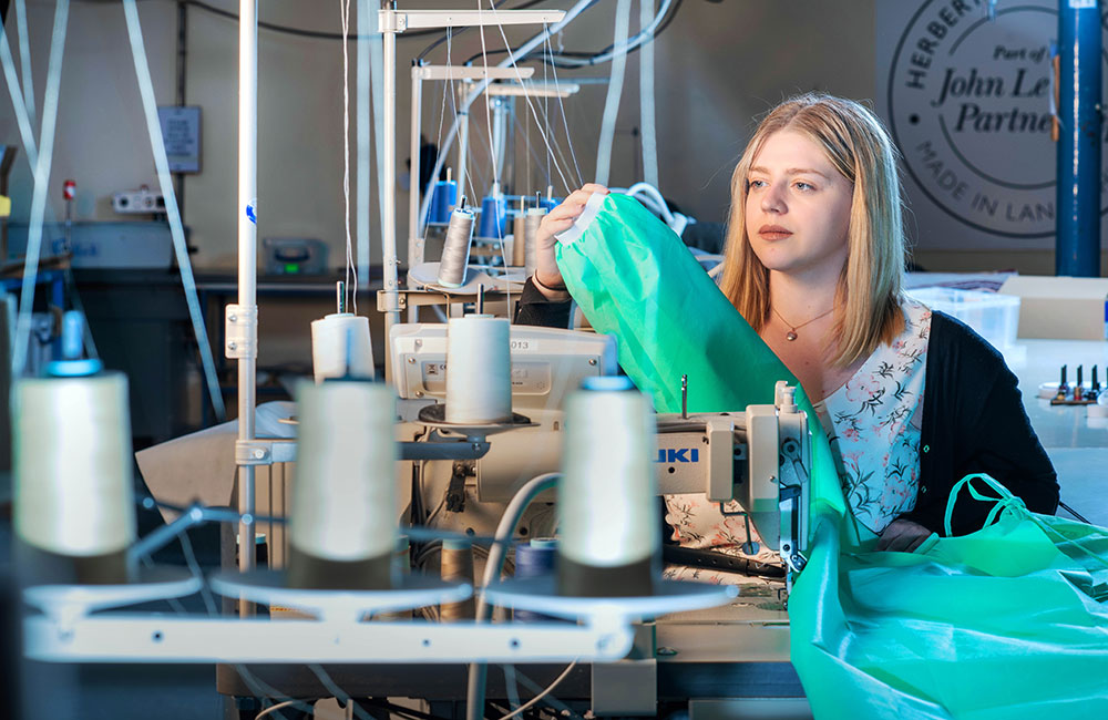 Young woman sewing NHS gowns