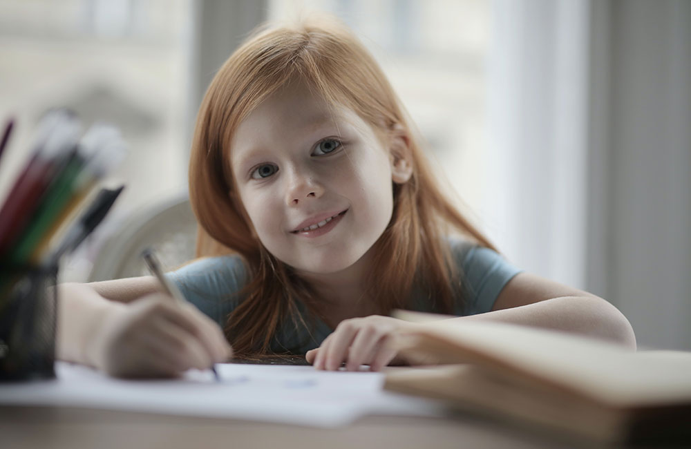 Young girl sat writing John Lewis letter