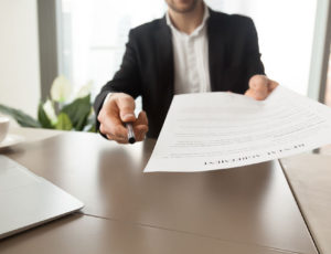 man holding lease agreement paper to sign