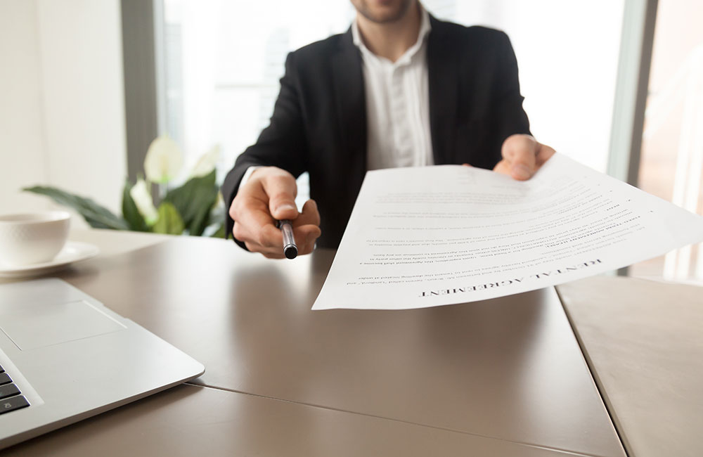 man holding lease agreement paper to sign