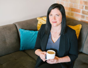 Young woman sitting on a sofa holding a cup of tea