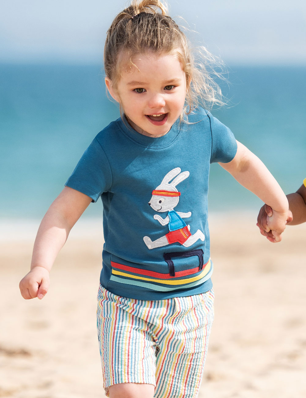 Young girl in blue Frugi T-Shirt with bunny