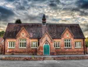 Red brick school image with dark clouds