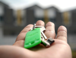Keys with green keyfob in the palm of hand - turnover lease