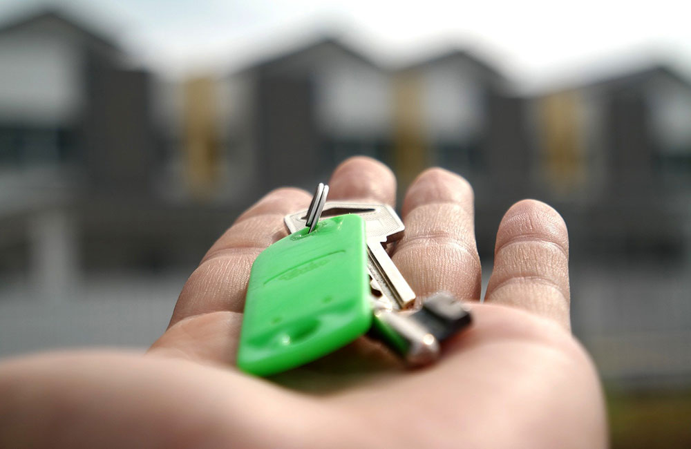 Keys with green keyfob in the palm of hand - turnover lease