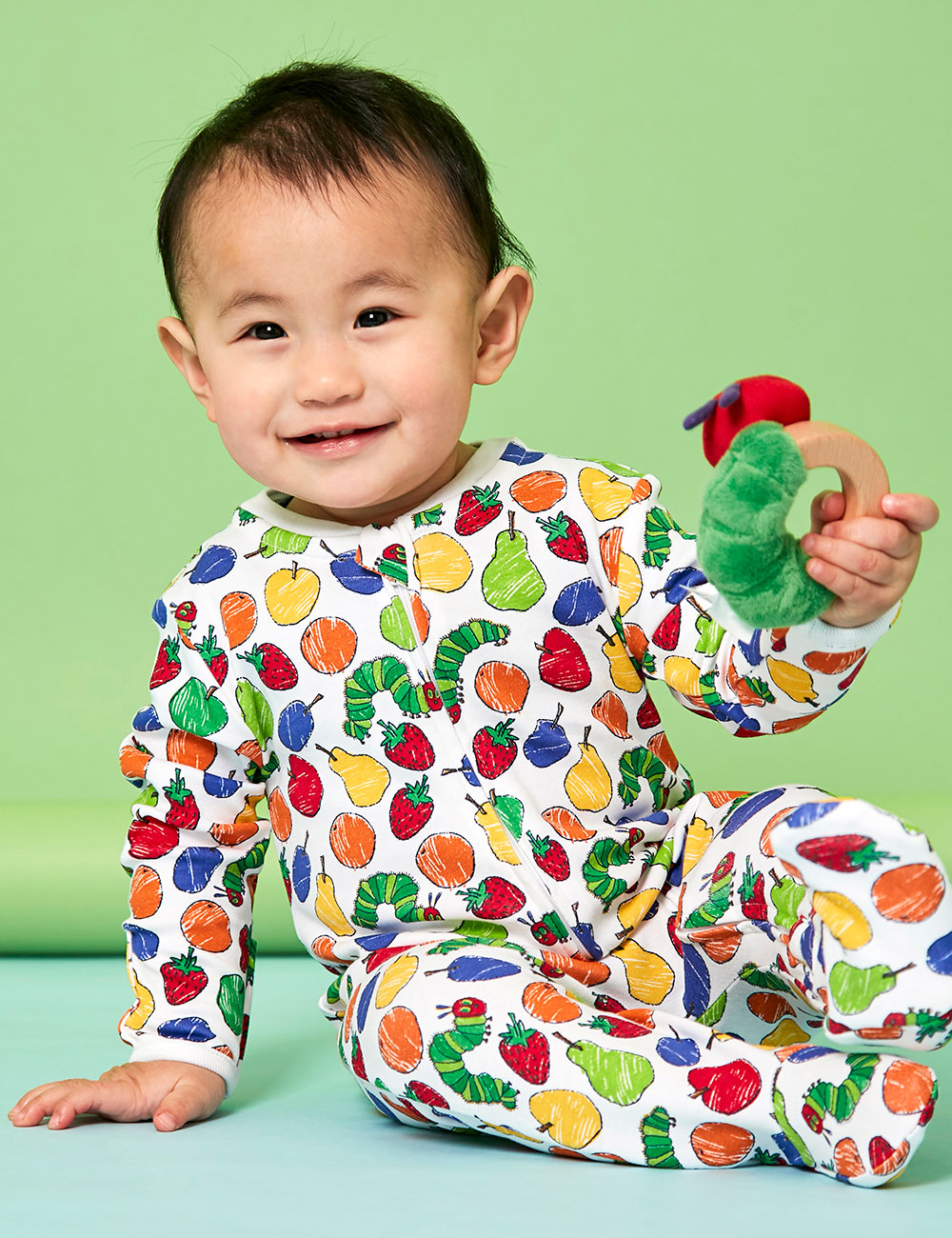 Baby boy in colourful The Very Hungry Caterpillar babygro