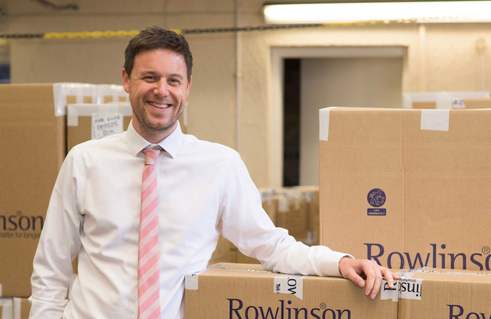 Rowlinson MD Neil Ward stood next to cardboard boxes