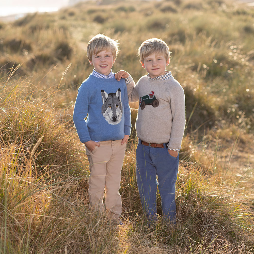 Two young boys in knitted Trotters jumpers with large motif