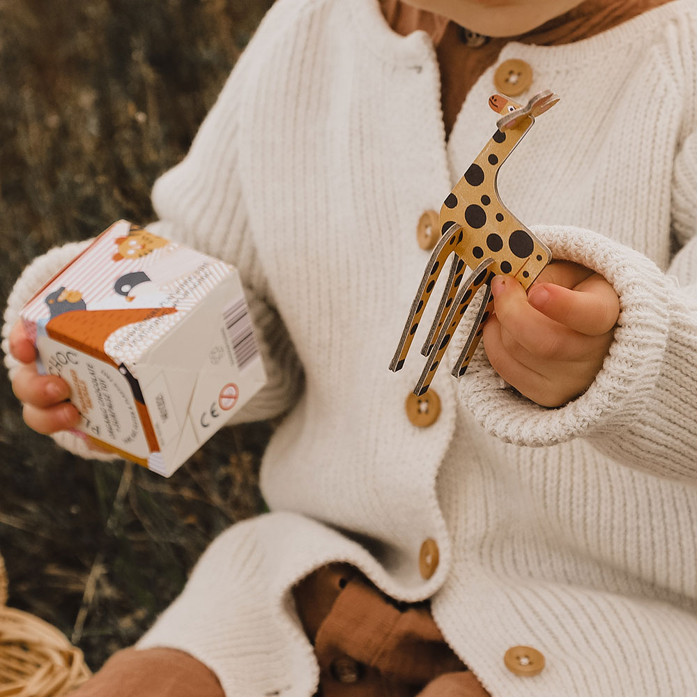 Baby holding a box and a small toy wooden giraffe