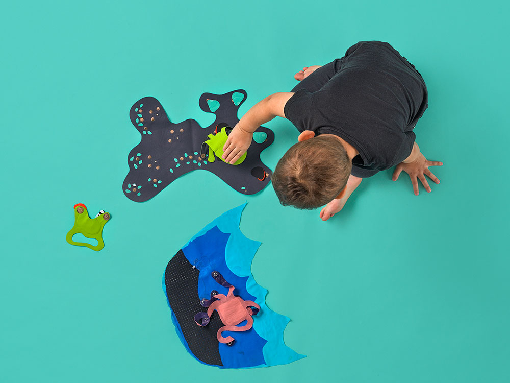 Young Boy playing on a green mat