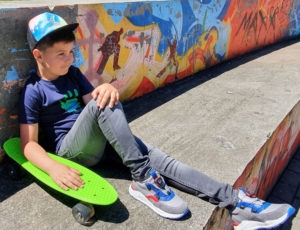 Young skater boy with Froddo shoes and green skateboard