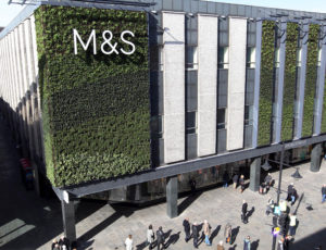 M&S building with sign on grass wall - Rainbow Sale