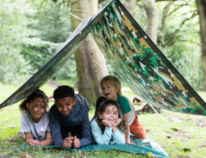 Four childen in the forest under a army den roof