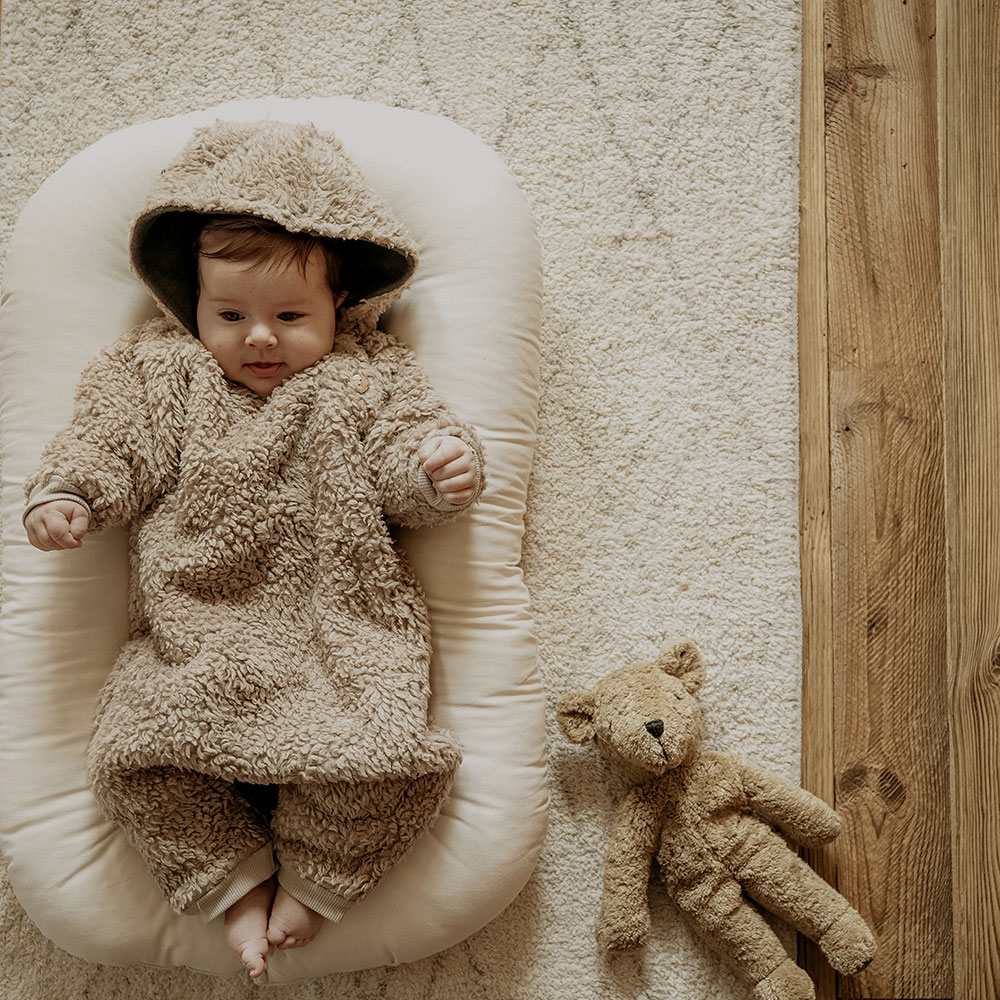 Baby in fluffy brown Organic Zoo all-in-one with matching Teddy bear