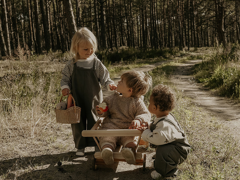 Three young children together in the woods