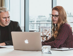 man and woman looking at a laptop in an office