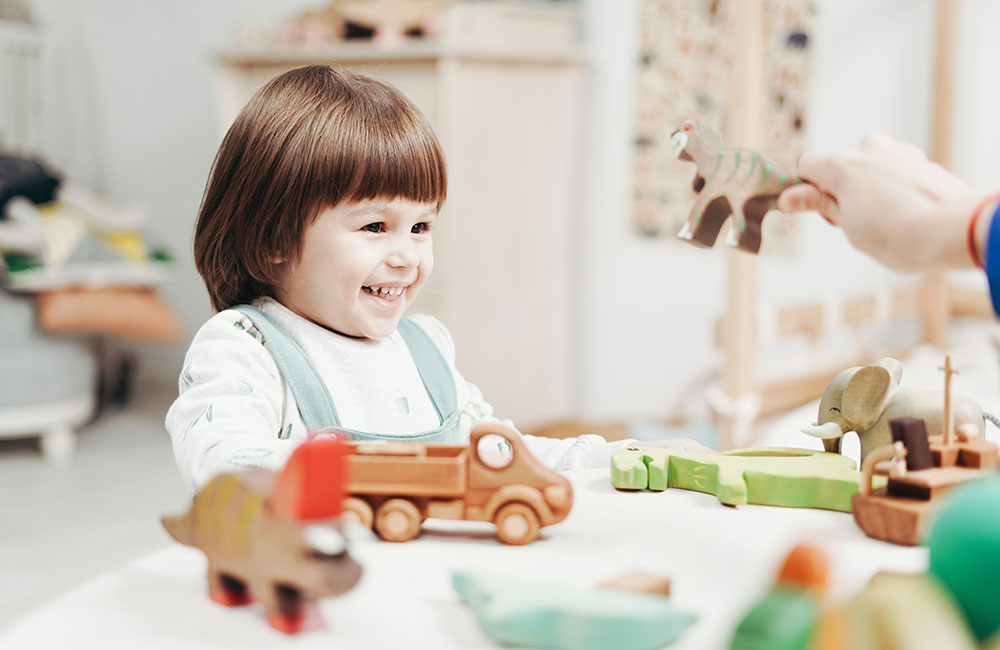 Young girl playing with wooden toys