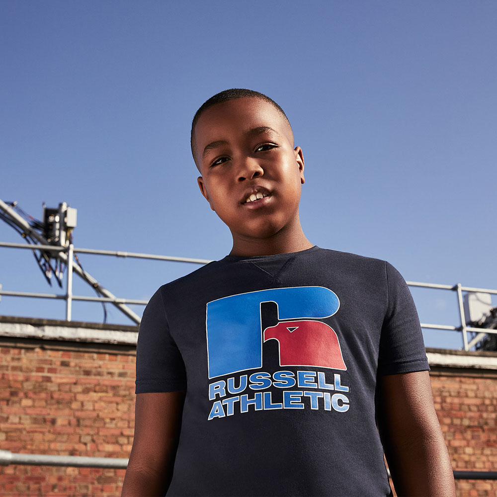 Young boy in blue T Shirt with Russell Athletic logo and Red Eagle R motif