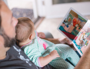 Dad reading a Christmas book to his baby
