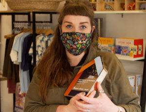Female Shop owner in face mask holding award