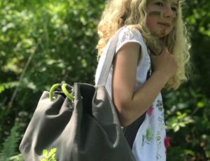 Young girl with blonde hair carrying a green backpack