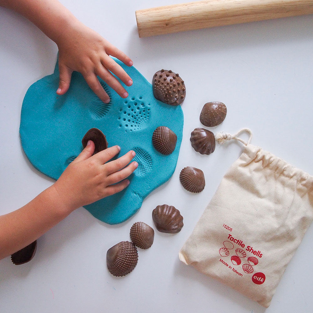 A young child playing with a shells game