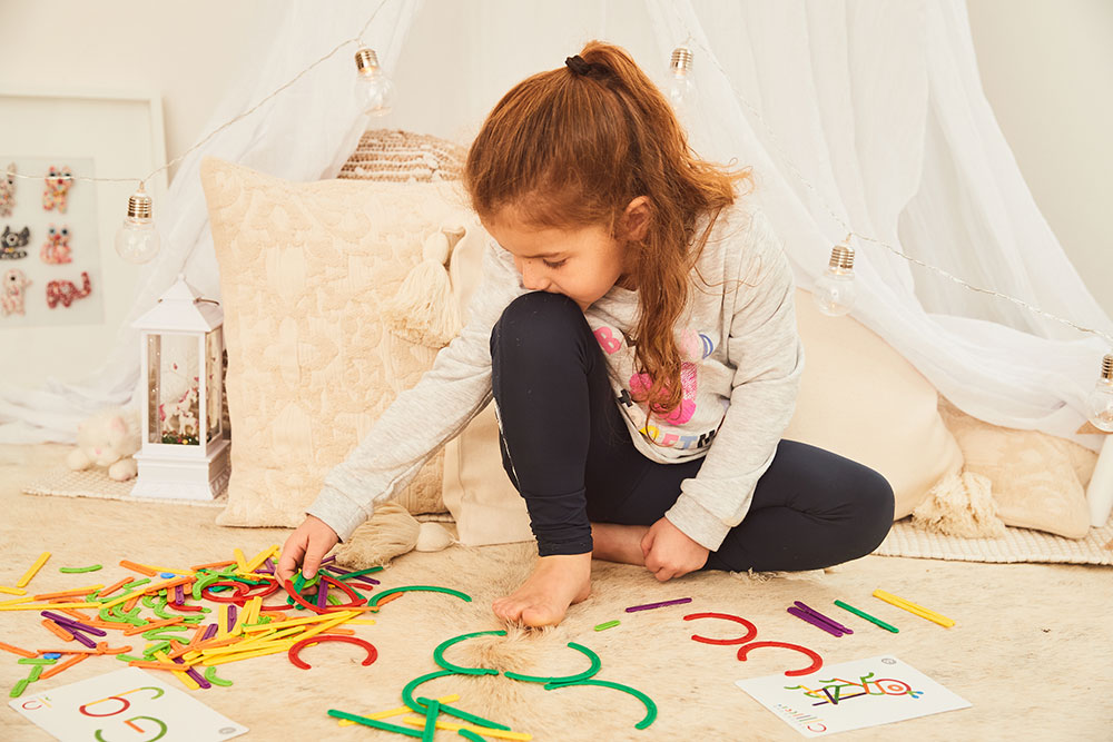 A young girl sat on the floor playing a game